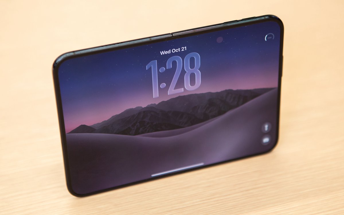 Разложенный iPhone Duo с экраном блокировки на деревянном столе
