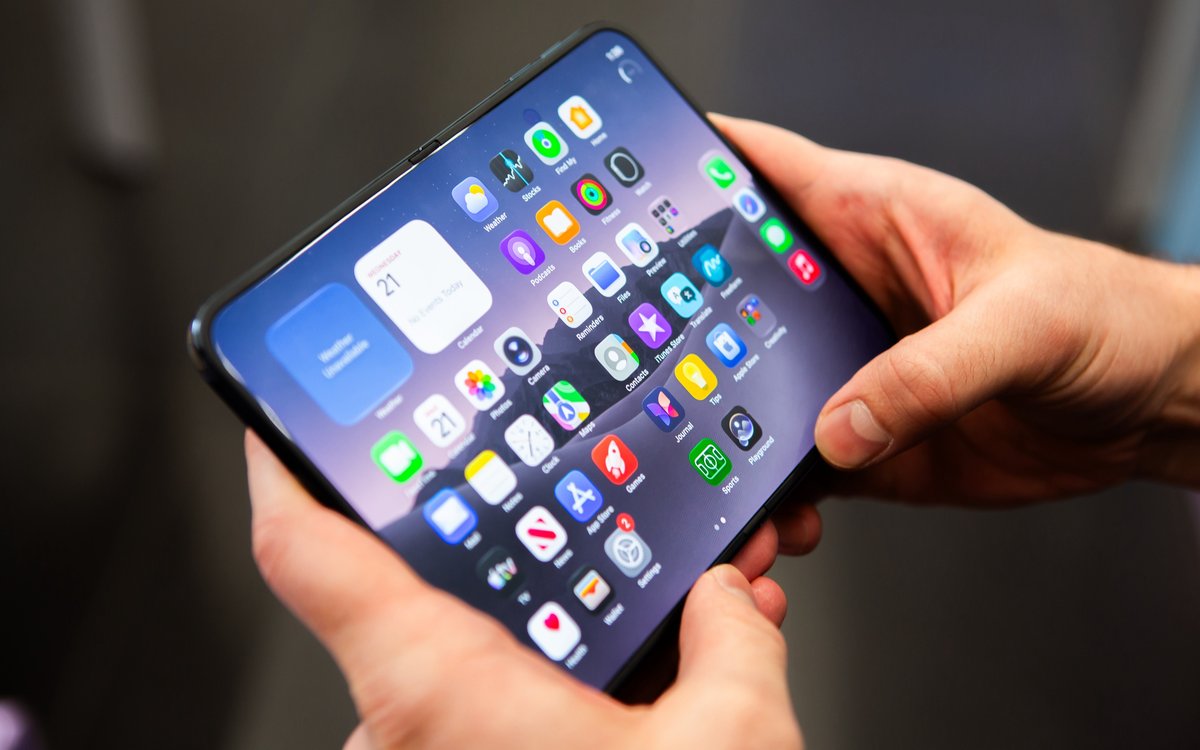 Руки держат разложенный iPhone Duo с рабочим столом iOS 27
